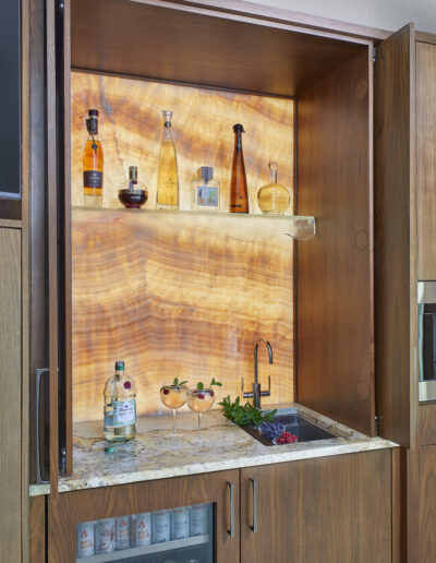 wet bar with liquor bottles and sink