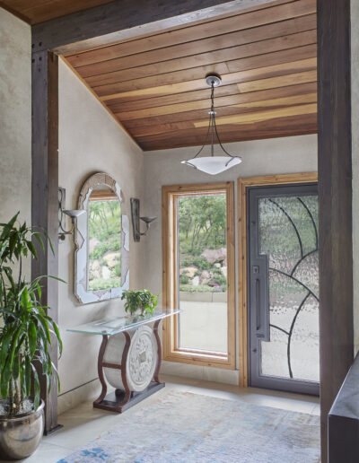 front door with wooden panel ceiling, door and large window