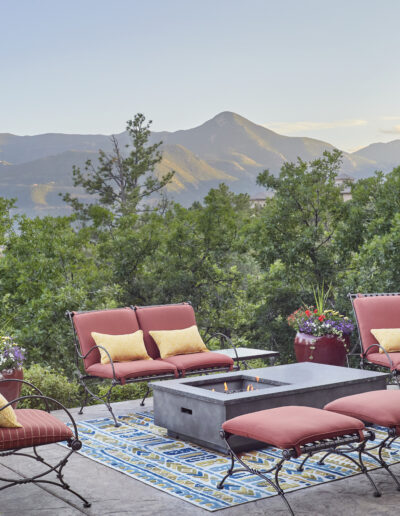 outdoor patio with red cushion chairs and mountain in background